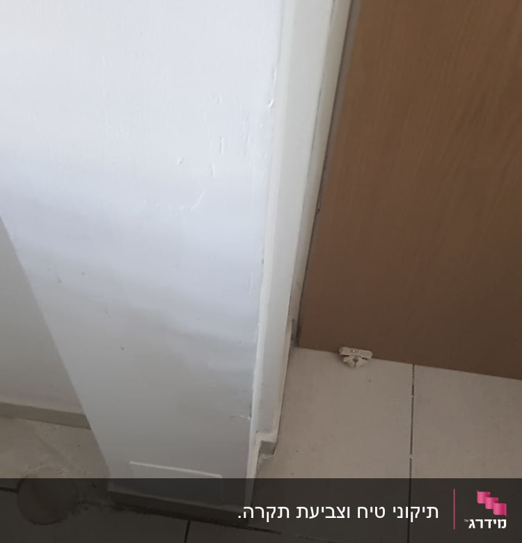 קיר צבוע בלבן ליד דלת עץ